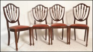A set of four 20th Century mahogany Hepplewhite style dining chairs, drop in seat pads raised on