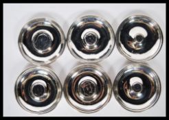 A set of 5 hallmarked silver peanut dishes each being adorned with coins to centre florins,