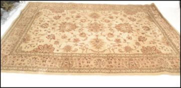 A 20th Century Persian Islamic rug having a beige ground with floral decoration to the central panel