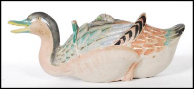 An early 20th Century Japanese Banko ware teapot in the form of a duck, being hand painted with