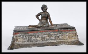 A early 20th Century 1930's cast spelter cigarette box, the lid having a seat girl on a central