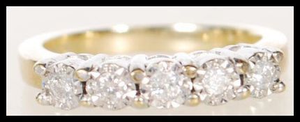 A hallmarked 9ct gold ring illusion set with five brilliant cut diamonds. Hallmarked Sheffield.