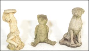 A group of three 20th Century composite stone garden statues to include a boxer dog, teddy bear