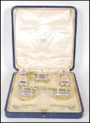 A cased Adie Brothers silver cruet set consisting of two pepperette's two table salts with blue