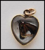 A reverse intaglio Essex crystal carved cabochon pendant of heart shape painted with a portrait of a