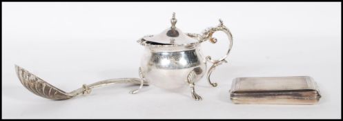 A silver hallmarked mustard pot condiment having a scrolled handle and floral garland rim, being