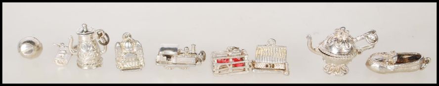 A group of vintage silver charm bracelet charms to include a lobster trap, shoe, garage which