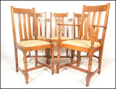A set of five early 20th Century Art Deco oak dining chairs, slated back with carved back rail, drop