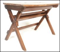 An early 20th Century vintage folding double school desk with recessed inkwell, raised on a