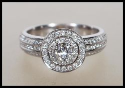 A hallmarked 9ct white gold and diamond cluster ring. The ring having concentric diamond set halos