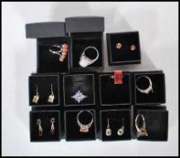 A collection of eleven cased silver ( stamped 925 ) dress rings and earrings, set with coloured
