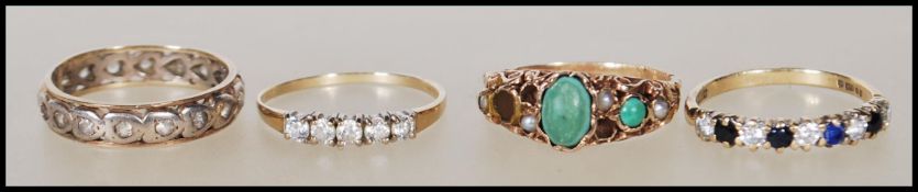 A collection of rings to include a stamped 375 pact gold ring set with two green stone cabochons and