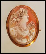 A 19th Century Victorian stamped 9ct gold shell cameo brooch of oval form. The brooch depicting a