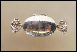 A contemporary designer white metal 925 silver pill / snuff box in the form of a wrapped sweet being