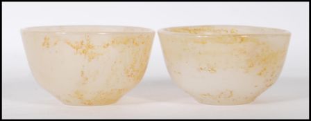 A pair of Chinese white jade bowls having applied brown mottled effect. Measures: 8cm diameter.