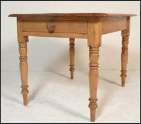 A Victorian 19th century country pine dining table being raised on turned legs with fitted frieze