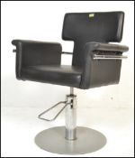 A pair of 20th Century barber chairs, the adjustable seats and backrests upholstered in faux black