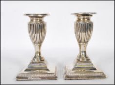 A pair of late Victorian silver London hallmarked candlesticks of stub form having single sconces,