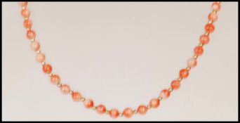 A vintage coral beaded necklace having a 9ct gold spring ring clasp with gold tone spacer beads.