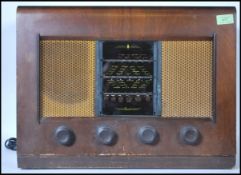 A vintage 20th Century walnut cased valve radio by Bush. Bush transfer logo to the top of the