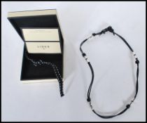 A Links of London sterling silver Teeth And Leather String necklace / bracelet , complete in box.