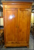 A 19th century French fruitwood  armoire wardrobe being raised on bracket feet with twin doors