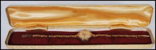 A hallmarked 9ct gold wrist watch of octagonal form by Garrard, having silvered dial with gilt baton