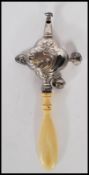 A silver hallmarked Victorian childs rattle with ivory / bone handle. Adorned with 4 bells. Marked