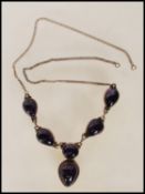 A stamped 925 silver necklace being set with a collar of six purple stone cabochons, having chain