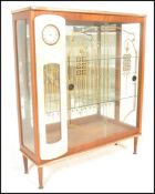 A vintage retro glass fronted mirror back cocktail display cabinet with painted glass detailing, the