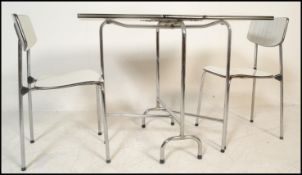 A vintage mid 20th Century drop leaf kitchen dining table raised on a chrome frame together with a