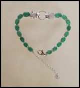 A silver and emerald line / tennis  bracelet with panther style designer clasp surrounding halo to
