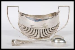 A silver hallmarked twin handled sugar bowl having a ribbed decoration having rubbed BIrmingham