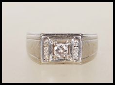 A 18k white gold diamond ring having central cut diamond flanked by three diamond accents to both