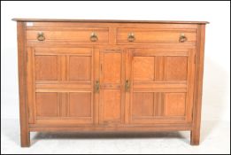 An early 20th Century oak sideboard buffet with quarter panel twin cupboard doors having two drawers