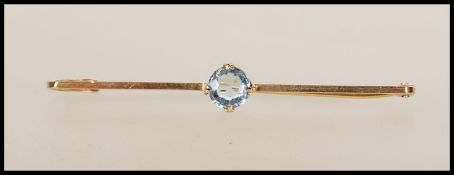 A 9ct gold ladies bar brooch with central claw mounted blue aquamarine coloured stone, pin verso.
