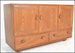 A mid century beech and elm Ercol Windsor pattern sideboard dresser. Raised on ball castors having