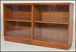 A mid century / circa 1960's teak wood and glass library bookcase cabinet. Of low form being solid