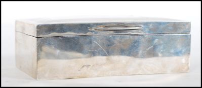 A silver hallmarked table top cigarette case having engine turned decoration, wood lined interior.