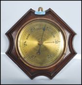 A 20th Century wall barometer of hexagonal form having around brass dial within a mahogany case.