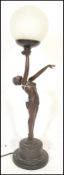 A Art Deco style table lamp in the form of a reclining nude lady holding a frosted glass ball