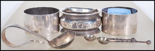 A collection of silver hallmarked items to include three napkin rings, a babies feeding /
