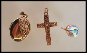 A group of three hallmarked 9ct gold pendants to include a locket of oval form with celtic knot