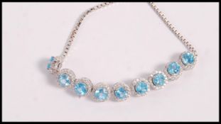 A stamped 925 silver bracelet set with round cut topaz and white accent stones having an