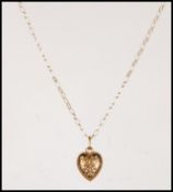 A 9ct gold heart shaped pendant having engraved swirl and foliate decoration to front and verso.