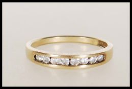 A hallmarked 9ct gold half eternity ring having suspension set diamonds in a channel setting.