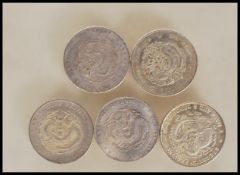 A group of five Chinese silver coins all being dragon coins, various leaders and character marks,