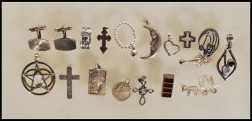 A collection of stamped 925 silver pendants and brooches to include a half moon pendant, a star