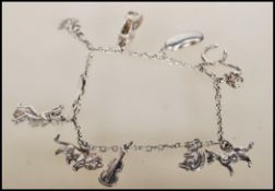 A silver charm bracelet having eleven charms including dog, violin, horse shoe, lion, bean, squirrel