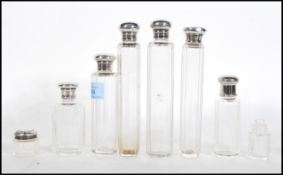 A collection of silver lidded faceted glass dressing table scent bottles to include a pair of Asprey